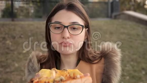 年轻女孩在镜头前吃着美味的披萨和鸡肉和蘑菇视频的预览图