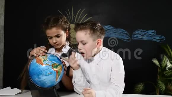 学校观念小学生们坐在书桌前玩地球仪孩子们在随意的地方指着视频的预览图