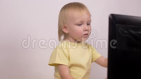 白种人小女孩金发碧眼地看着电脑笔记本电脑的笑声和鬼脸特写情绪视频的预览图