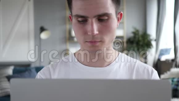 疲劳男子在笔记本电脑上工作时揉眼睛的特写镜头视频的预览图