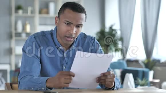 年轻的非洲男人在阅读文件后心烦意乱感到悲伤视频的预览图