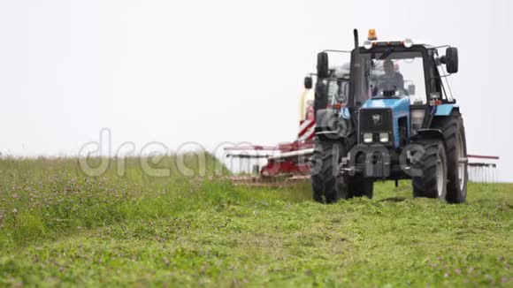 农用拖拉机在农场草地上切割视频的预览图