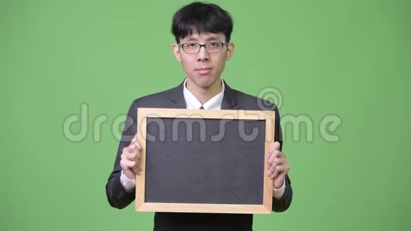 年轻的亚洲商人展示黑板摄像机视频的预览图
