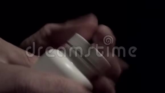 双手打开一罐药丸然后用手掌特写视频的预览图