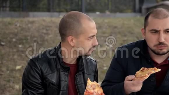 两个人坐在公园里吃海鲜披萨视频的预览图