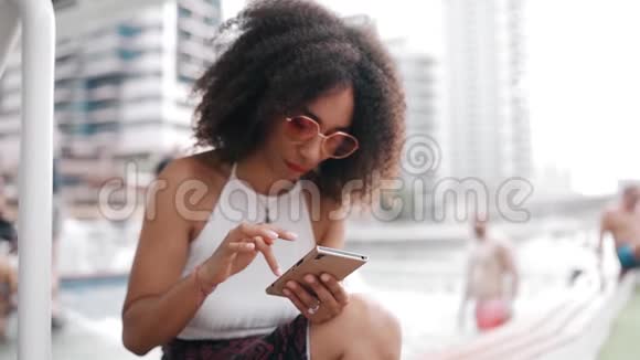 非洲裔美国妇女在城市户外使用手机视频的预览图
