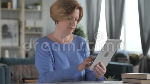 老年妇女在使用平板电脑时应对经济损失视频的预览图