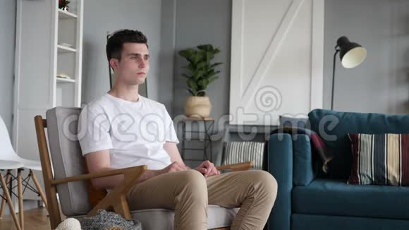 肩膀疼痛的男人坐在沙发上视频的预览图