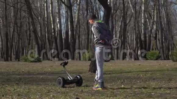男孩走在公园里把陀螺推到自己面前视频的预览图