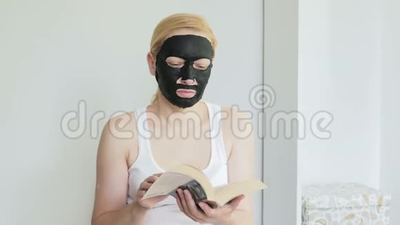 一个戴着黑色化妆面具的女人在看书视频的预览图