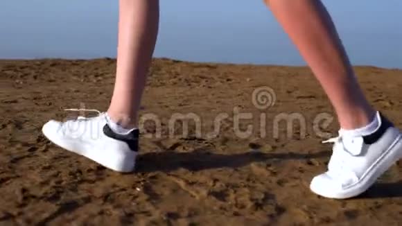 穿着运动鞋在海滩上奔跑的女人的脚视频的预览图