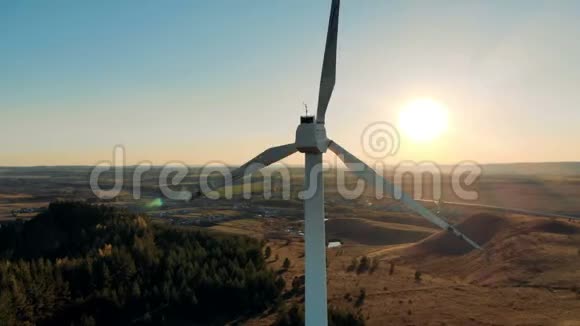 太阳和在其背景中旋转的风力涡轮机风能风力发电理念视频的预览图