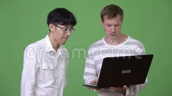 两个悲伤的年轻多民族商人一边用笔记本电脑一边收集坏消息视频的预览图