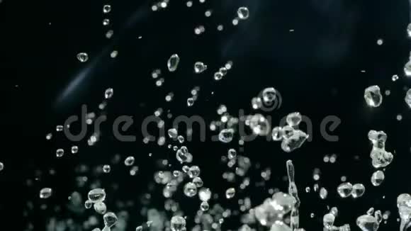 水滴在黑色背景下在空气中上升慢速水溅在黑色背景上视频的预览图
