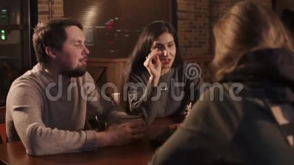 一群朋友中的布鲁内特女孩正在咖啡馆的餐桌上讲话视频的预览图