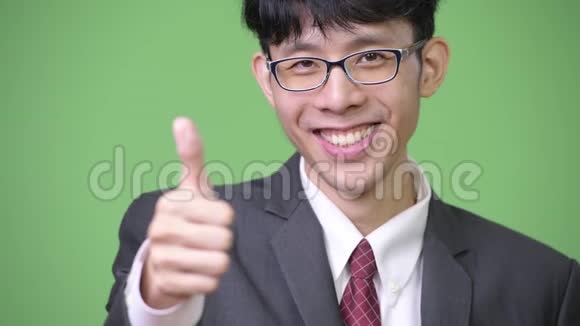 年轻快乐的亚洲商人微笑着对着镜头竖起大拇指视频的预览图