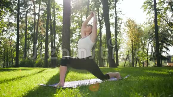 四K镜头40岁的女人在当地公园的垫子上做健身运动照顾他们的精神和视频的预览图