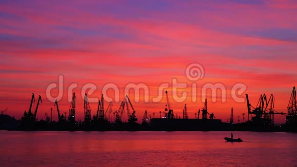 保加利亚瓦尔纳港工业起重机和货船的日落轮廓视频的预览图