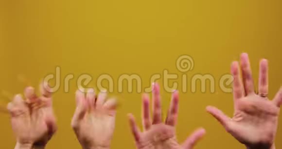 一个男人和一个女孩的手是有趣的移动和抽搐在一个黄色的背景孤立在工作室广告视频的预览图