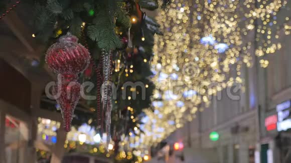 红色的圣诞玩具挂在云杉的树枝上城市的节日装饰视频的预览图
