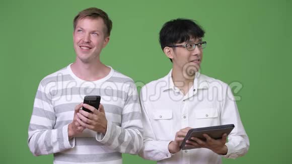两个快乐的年轻多民族商人使用电话和数字平板电脑来社交媒体的概念视频的预览图