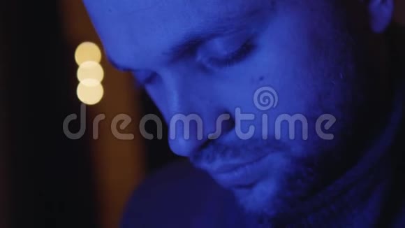 年轻的大胡子睡觉的人脸上闪着蓝色的光正在觉醒视频的预览图