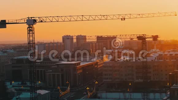 工业城市中部的一个建筑工地起重起重机工作日落静态射击视频的预览图