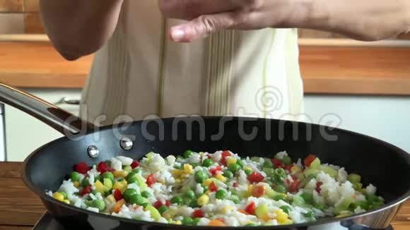 女人在平底锅上用米饭腌制蔬菜慢动作视频视频的预览图