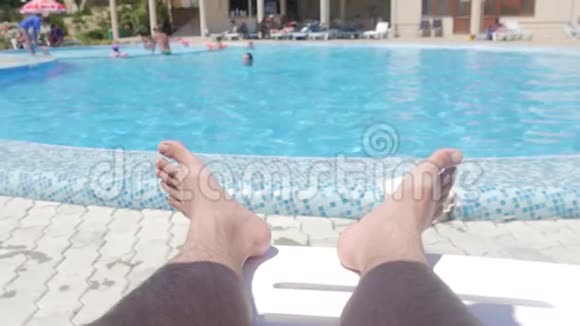 在游泳池旁享受暑假在阳光明媚的夏日关闭男性脚和池边水视频的预览图
