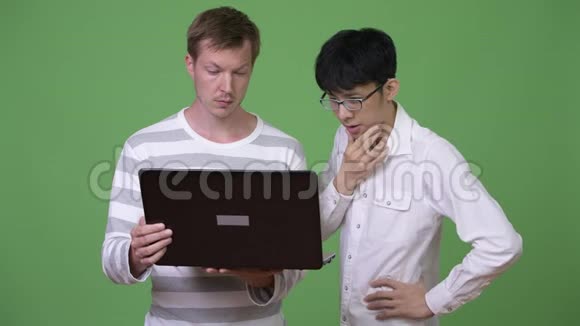 两个年轻的多民族商人一起与笔记本电脑会面视频的预览图