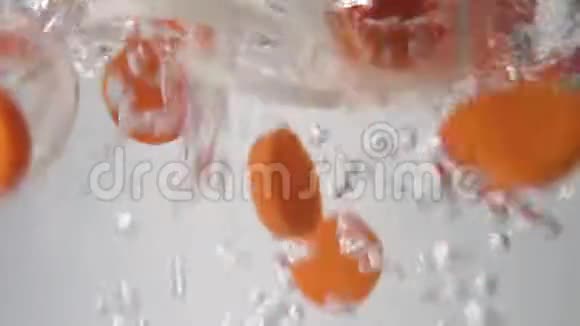 切好的胡萝卜和洋葱圈落入沸水中宏观观点视频的预览图