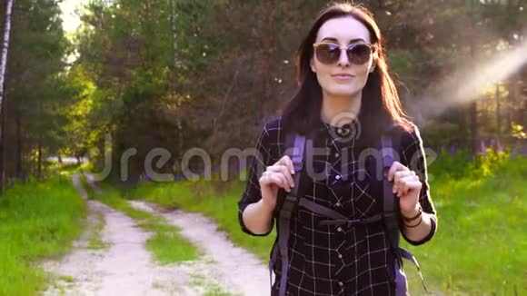 在阳光森林徒步旅行的旅游女孩的肖像视频的预览图