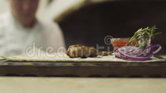 厨师把肋骨放在皮塔面包上视频的预览图