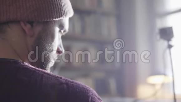 成熟的男人穿着棕色套头衫坐在旧的灰色小相机前视频的预览图