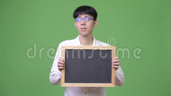 年轻的亚洲商人拿着黑板思考视频的预览图