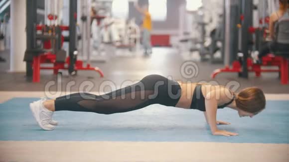 一名运动员女子在健身房训练做俯卧撑视频的预览图