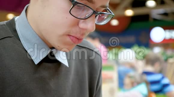 一个年轻人正在购物中心吃汉堡包视频的预览图
