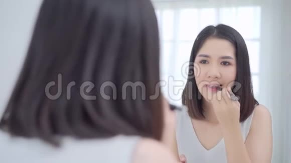 快乐女性使用美容化妆品来提高自己准备在家里的卧室工作视频的预览图