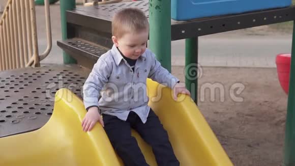 小男孩在操场上滑着滑梯从孩子们下来视频的预览图