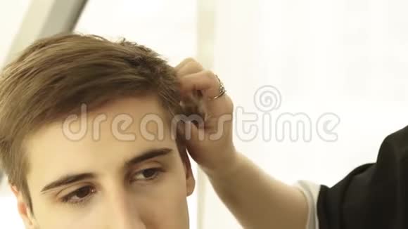 理发师在美发沙龙男性理发前触摸和寻找头发关闭剪发工视频的预览图