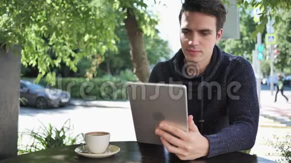激动人心的男人坐在咖啡馆的平台上庆祝成功视频的预览图