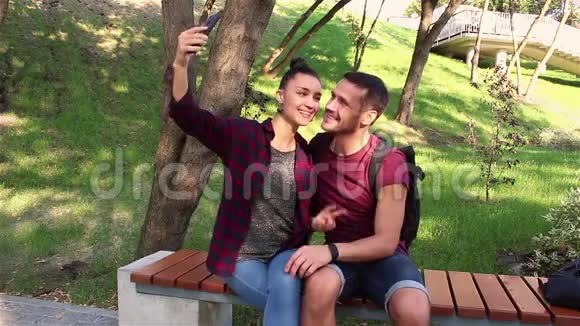 恋爱中的年轻夫妇被拍到坐在公园的长凳上视频的预览图