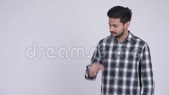 年轻快乐留胡子的印度男人拍手指并展示一些东西的肖像视频的预览图