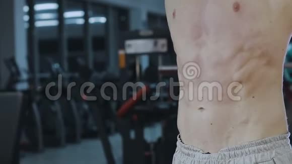 这个人在健身房训练后展示腹部肌肉视频的预览图