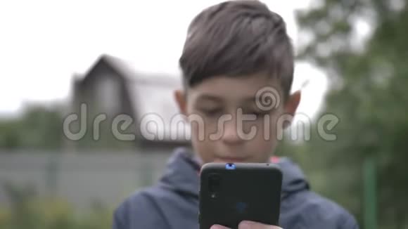 男孩用手机在户外关门移动摄像头视频的预览图