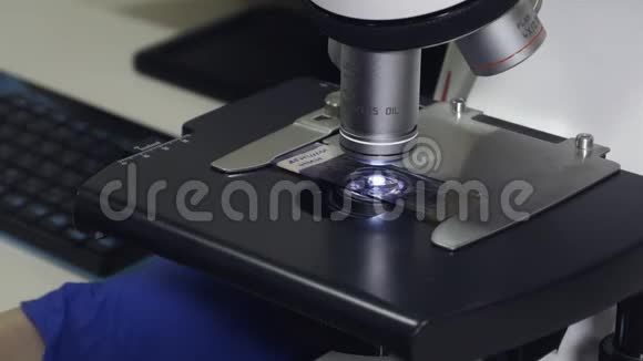 在显微镜的特写下实验材料的平台靠近显微镜的镜头视频的预览图