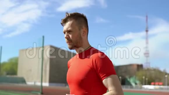年轻运动员在体育场跑道上跑步视频的预览图