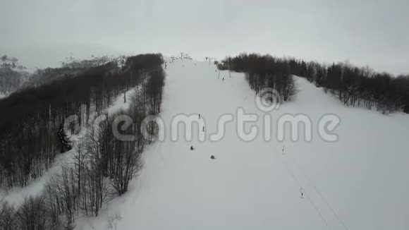 在山上乘坐滑雪缆车的人滑雪场的空中景观视频的预览图