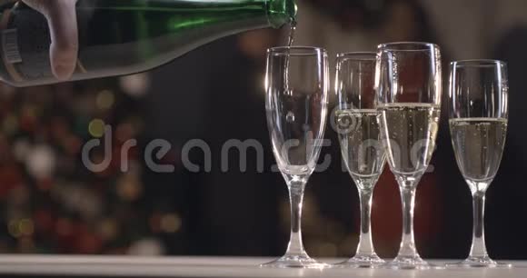 香槟倒入玻璃杯慢动作除夕在现代圣诞树的背景下视频的预览图