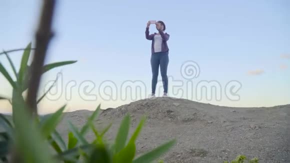 站在山顶上的年轻女子拍摄大海日落希腊克里特岛视频的预览图